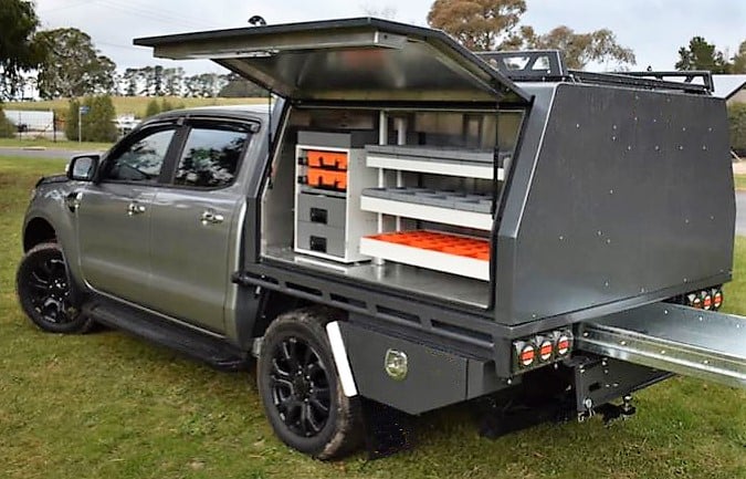Truck bed with storage system and open rolacase toolbox on grassy area