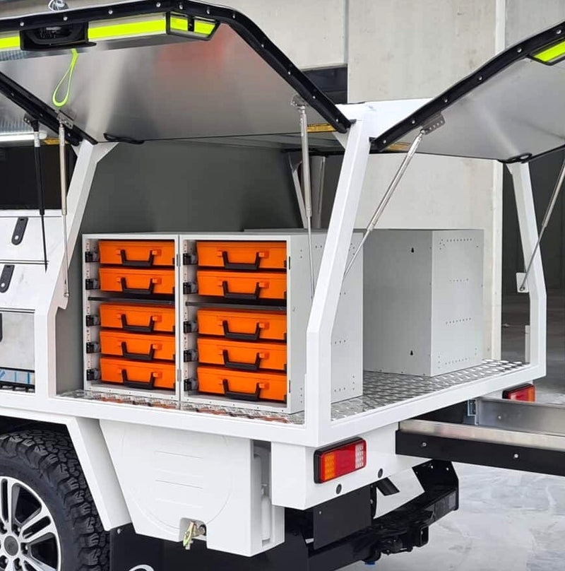 Truck bed with open Rolacase storage compartments containing orange boxes.
